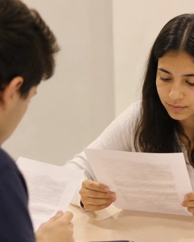 Grupo sentado numa sala clara enquanto uma pessoa defende um ponto de vista